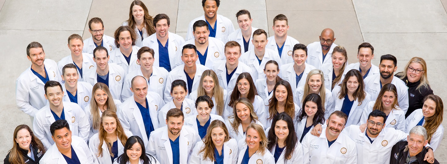2020 residents posing as a group in white lab coats outside