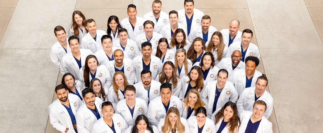 2020 residents posing as a group in white lab coats outside